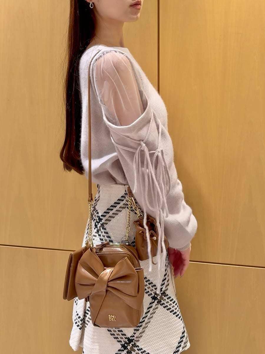 ホワイト系のスカート、ピンク系のニット/セーター、イエロー系のショルダーバッグを着用したレディースの冬コーディネートの6枚目の写真