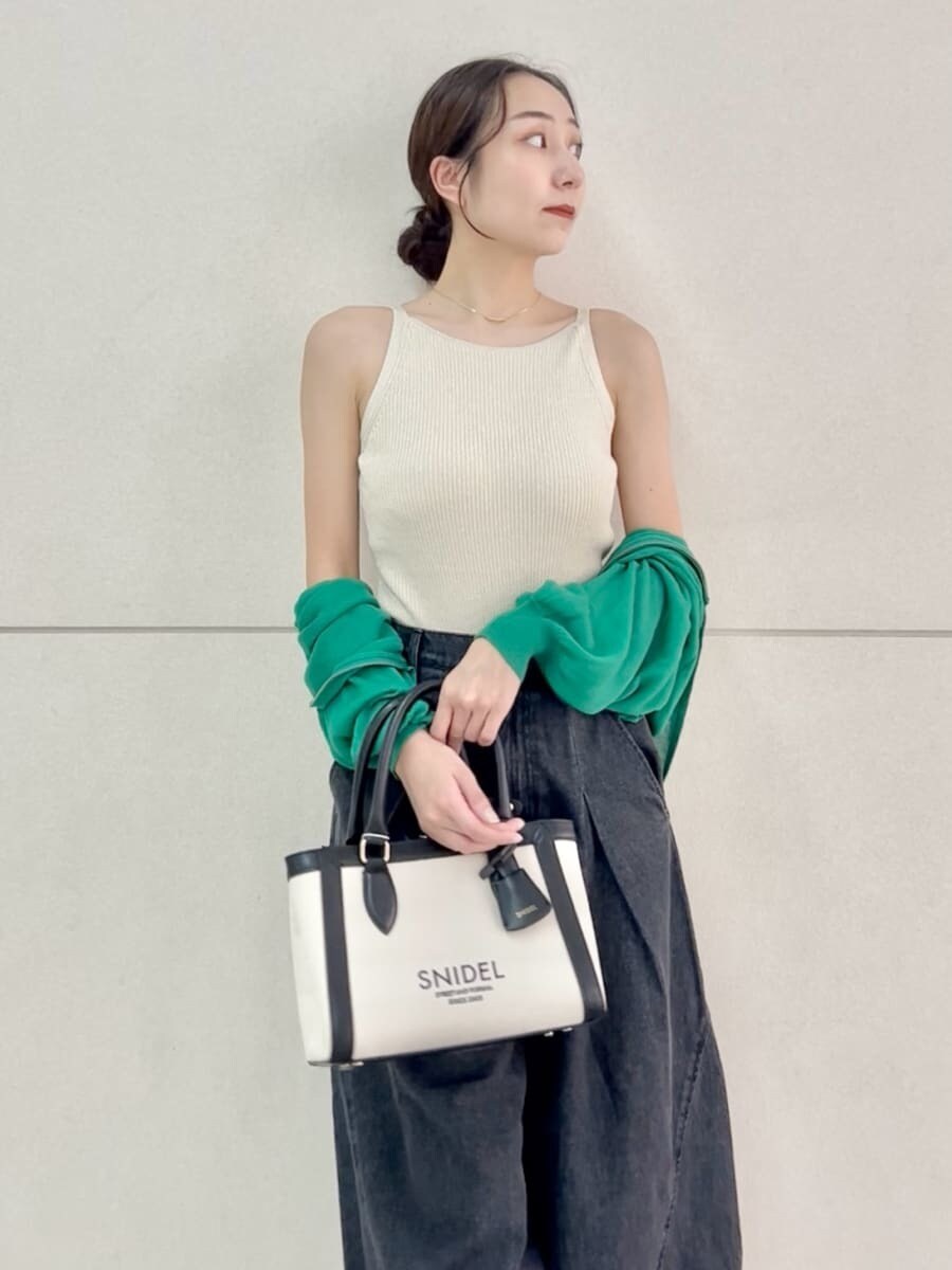 ブラック系のデニムパンツ、ベージュ系のニット/セーター、ブラック系のハンドバッグを着用したレディースの夏コーディネートの5枚目の写真