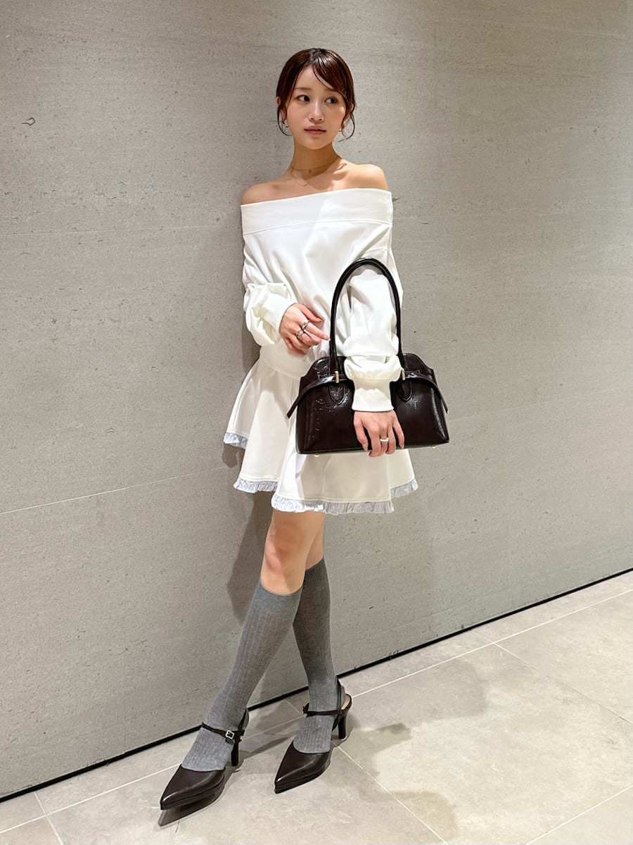 ホワイト系のワンピース、ブラウン系のパンプス、ブラウン系のボストンバッグを着用したレディースの秋コーディネートの4枚目の写真