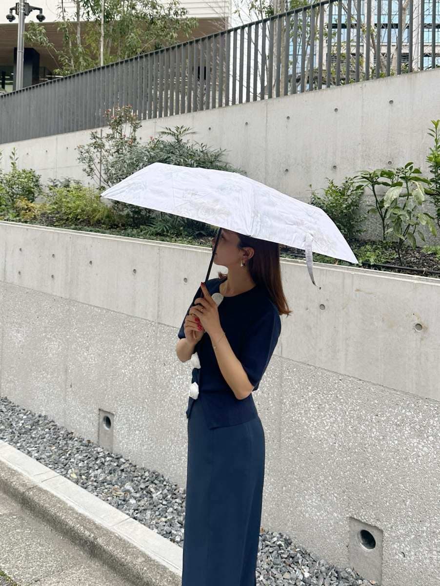 ブルー系のスカート、ブルー系のカーディガン/ボレロ、ピンク系の折りたたみ傘を着用したレディースの春コーディネートの4枚目の写真