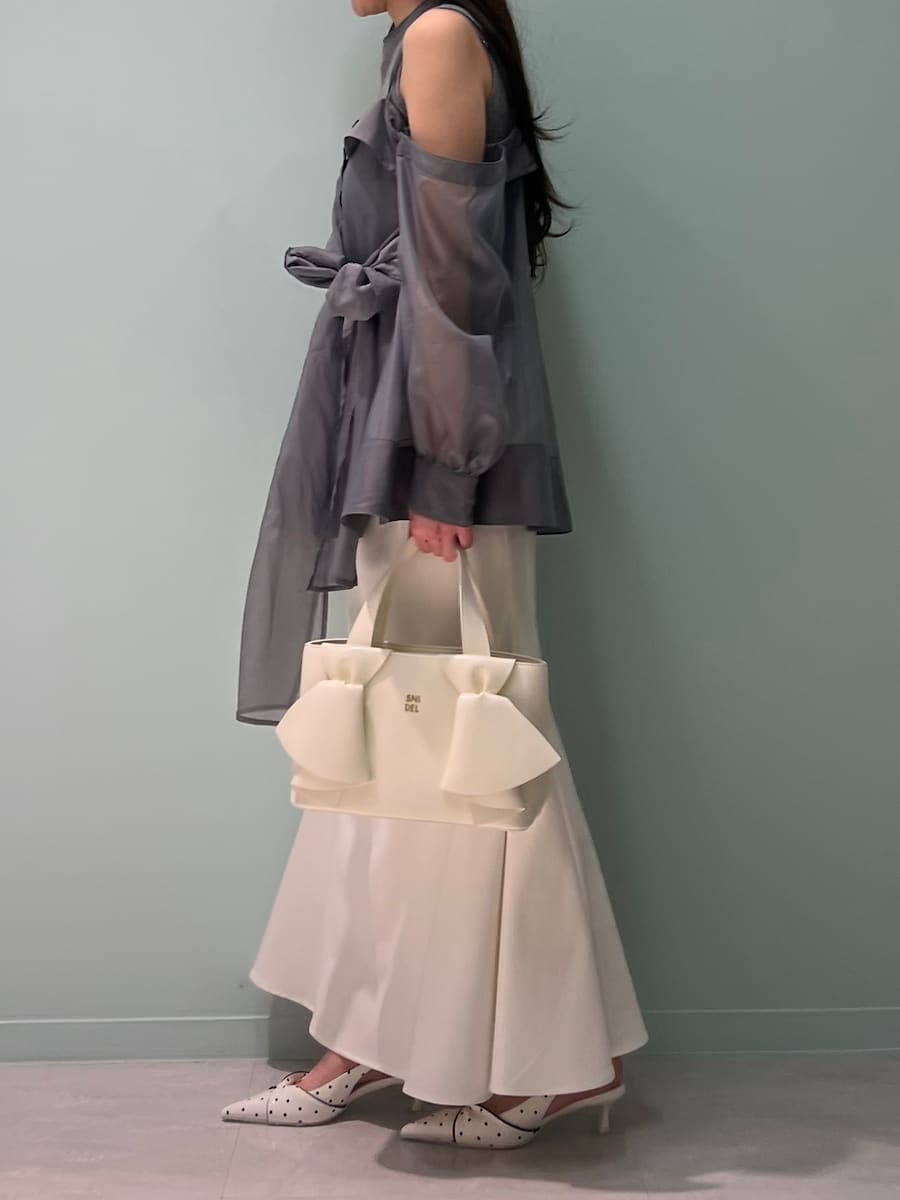 ホワイト系のスカート、グレー系のニット/セーター、その他のパンプスを着用したレディースの春コーディネートの3枚目の写真