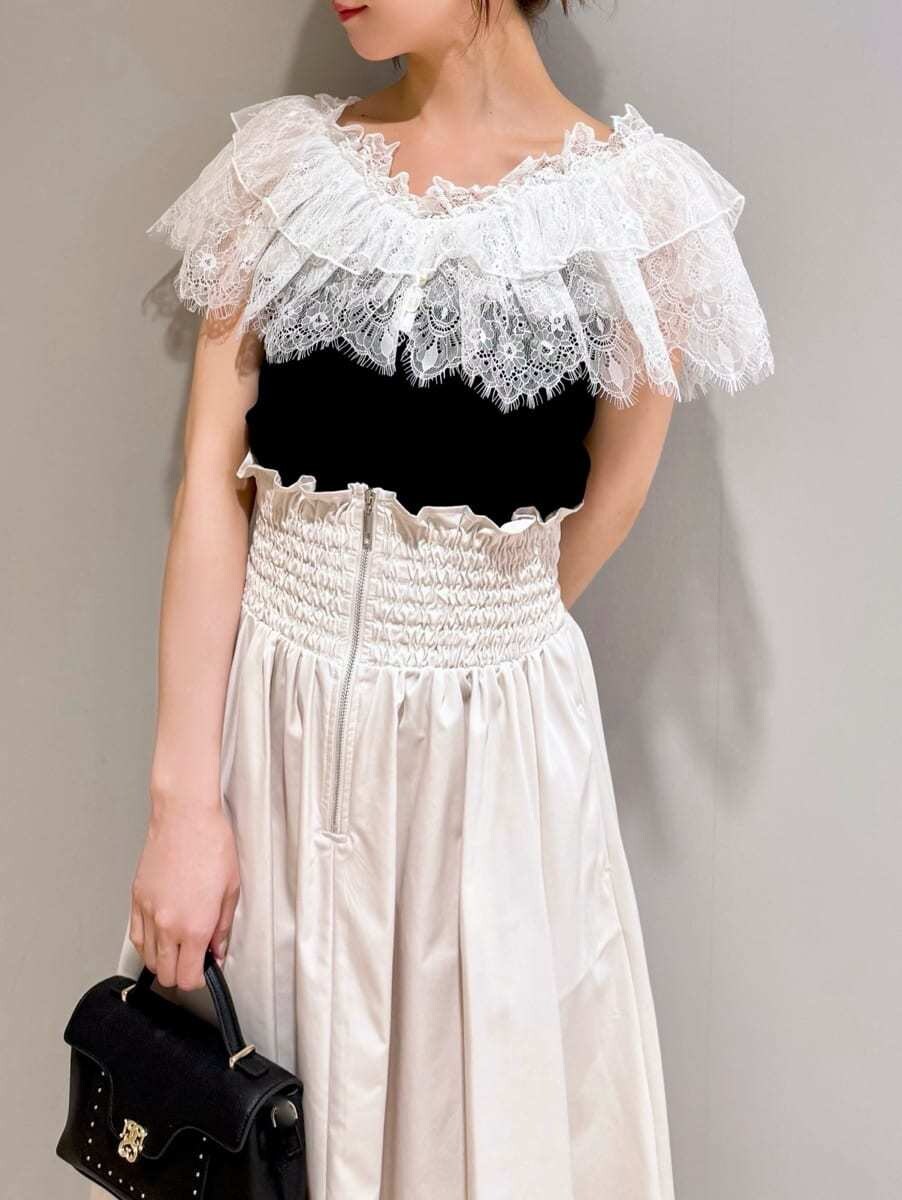 ブラック系のニット/セーター、ホワイト系のスカート、ブラック系のショルダーバッグを着用したレディースの夏コーディネートの5枚目の写真