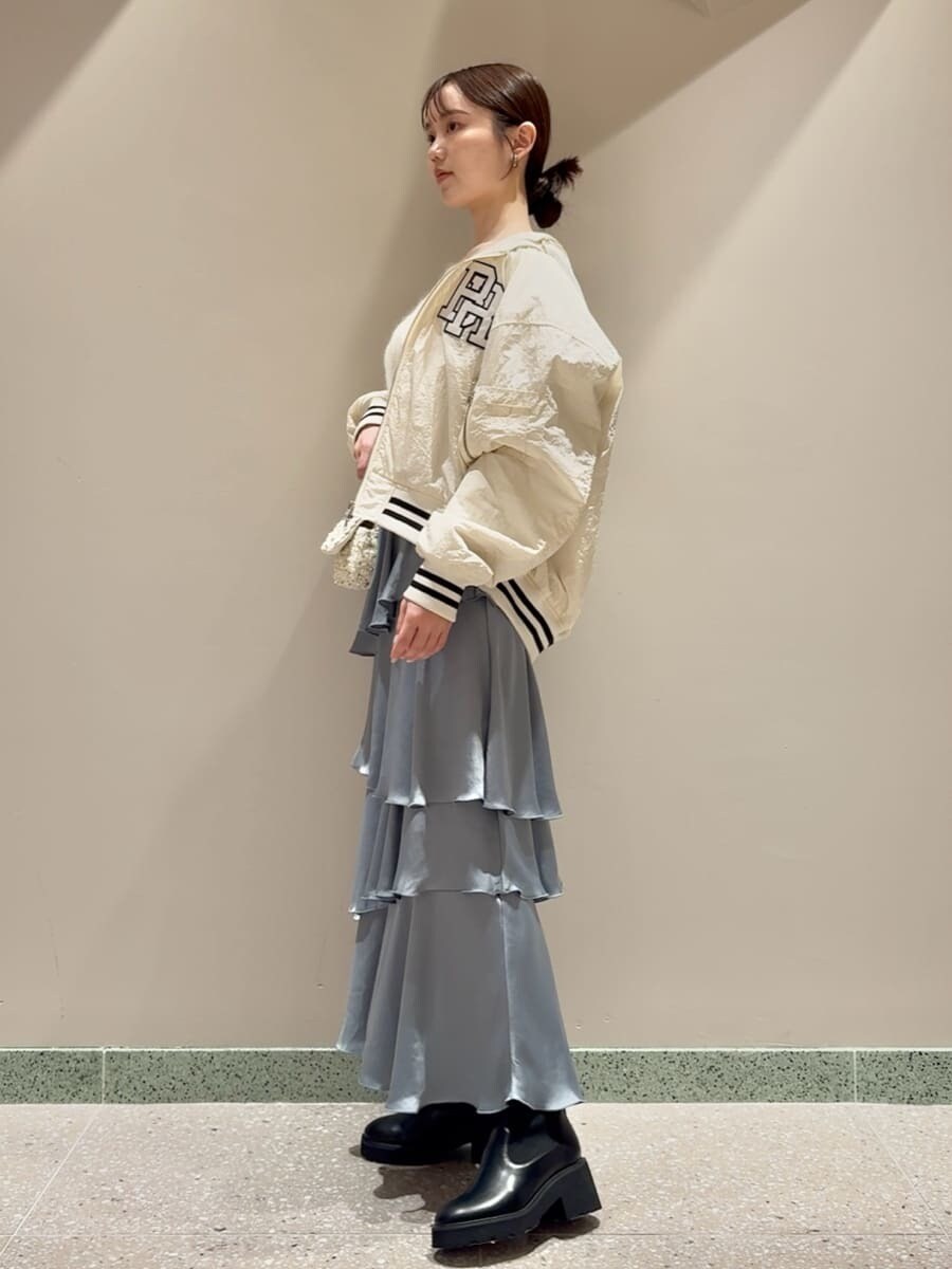 ホワイト系のブルゾン、ホワイト系のニット/セーター、ブルー系のスカートを着用したレディースの秋コーディネートの2枚目の写真