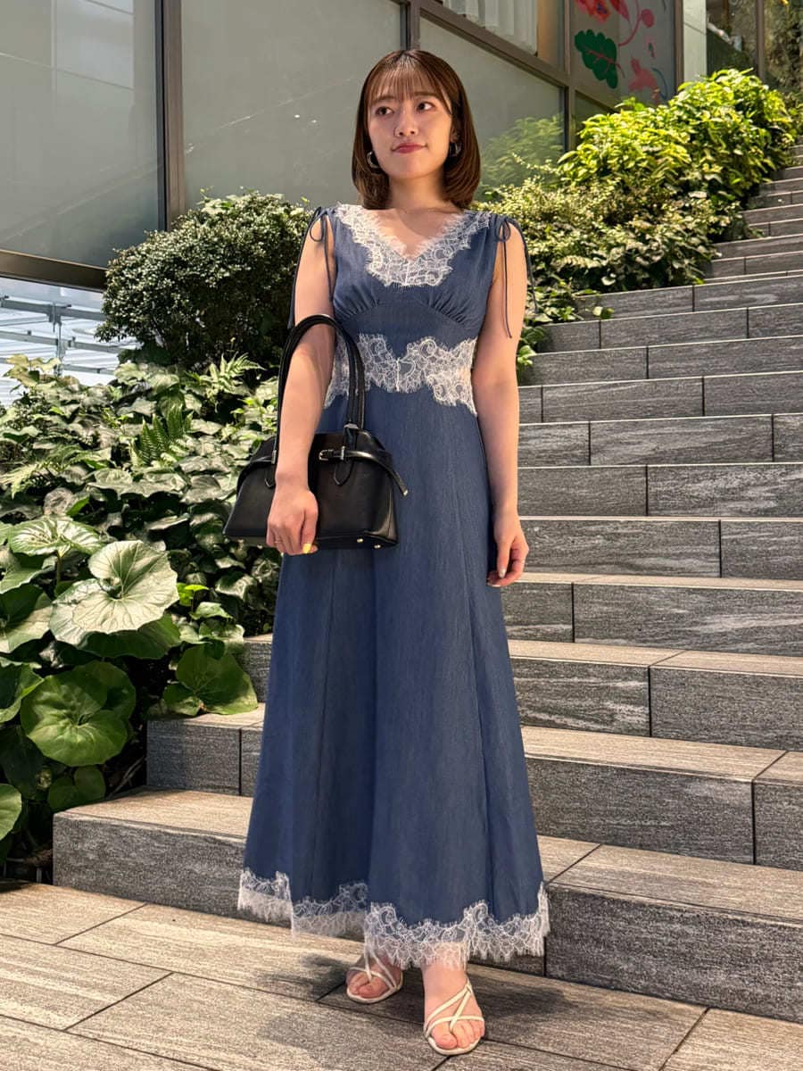 ホワイト系のサンダル、ブルー系のワンピース、ブラック系のボストンバッグを着用したレディースの夏コーディネートの2枚目の写真