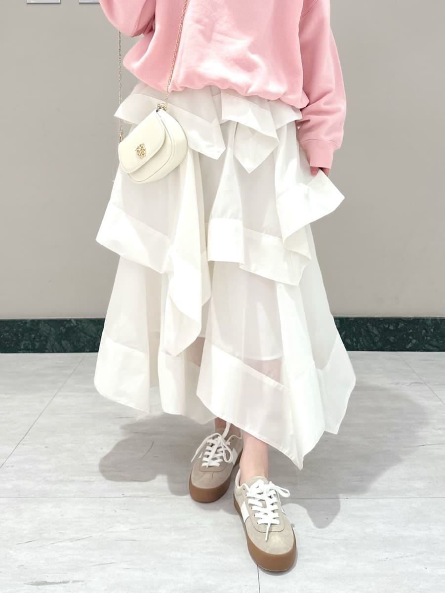 ホワイト系のスカート、ピンク系のスウェット、ホワイト系のショルダーバッグを着用したレディースの春コーディネートの3枚目の写真