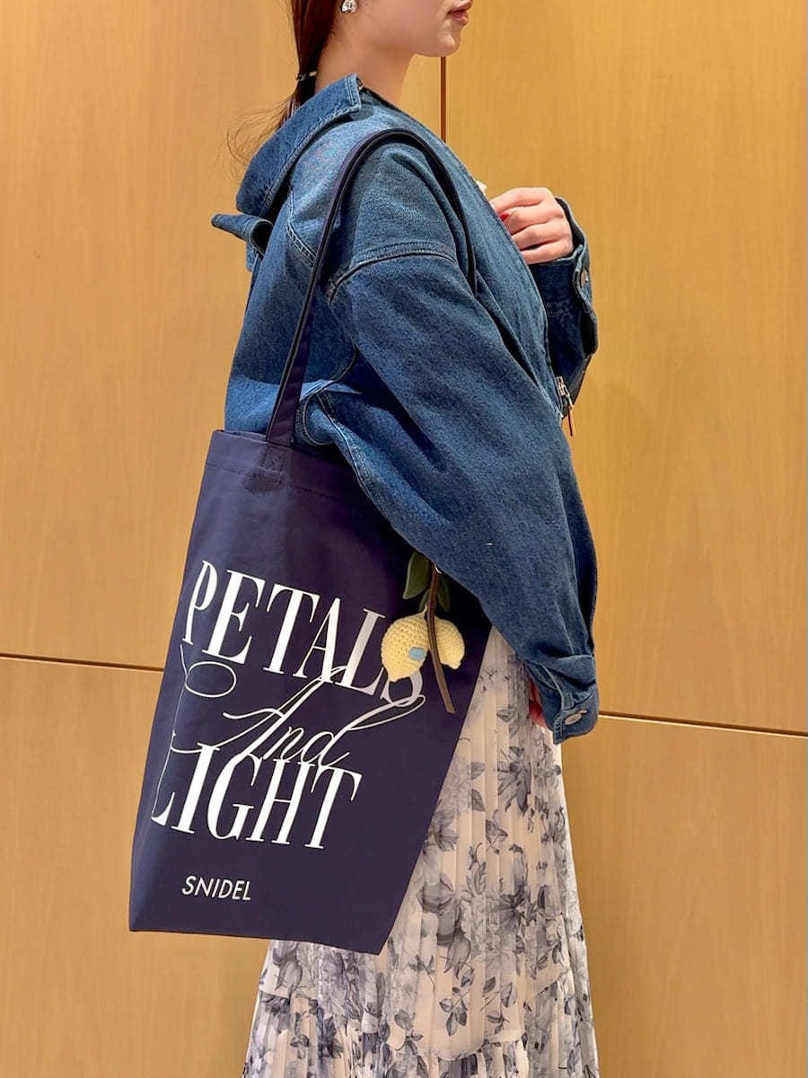 ブルー系のブルゾン、イエロー系のワンピース、ブルー系のトートバッグを着用したレディースの冬コーディネートの8枚目の写真