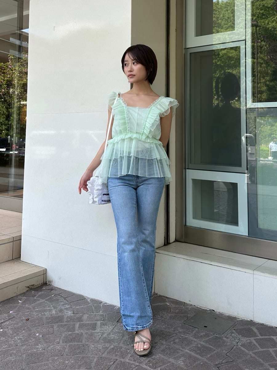 グリーン系のシャツ/ブラウス、ブルー系のデニムパンツ、ホワイト系のショルダーバッグを着用したレディースの春コーディネートの6枚目の写真
