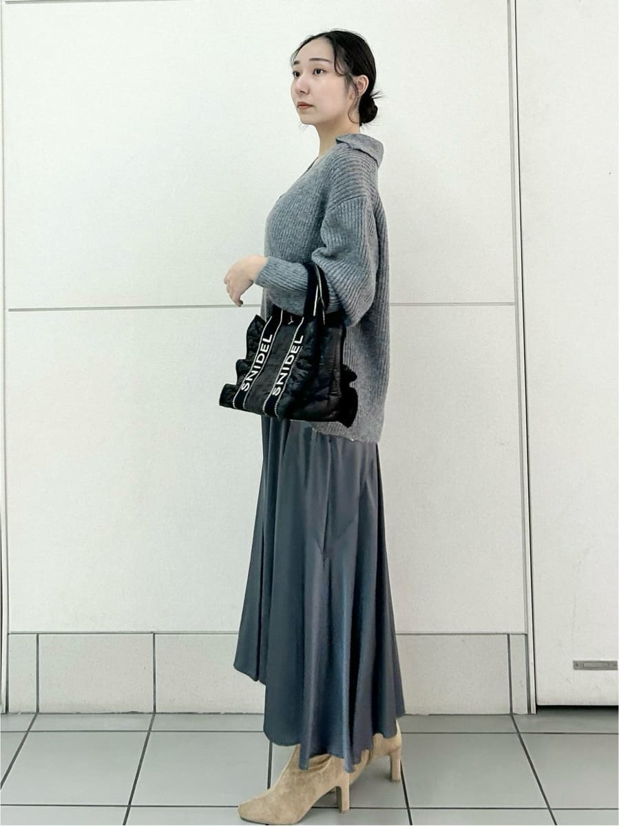 ベージュ系のブーツ、ブラック系のハンドバッグ、グレー系のワンピースを着用したレディースの冬コーディネートの2枚目の写真