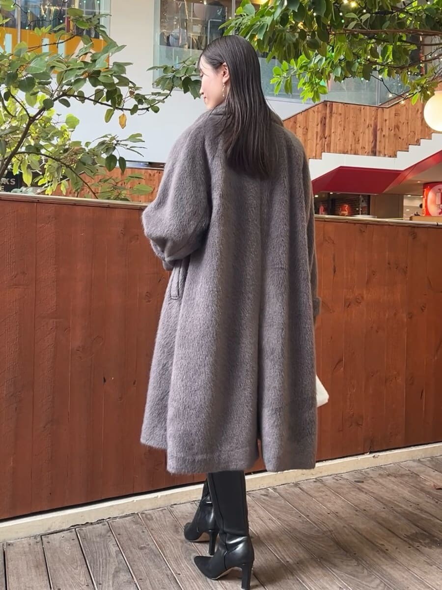 ブラック系のブーツ、グレー系のチェスターコート、ブルー系のその他パンツを着用したレディースの冬コーディネートの4枚目の写真