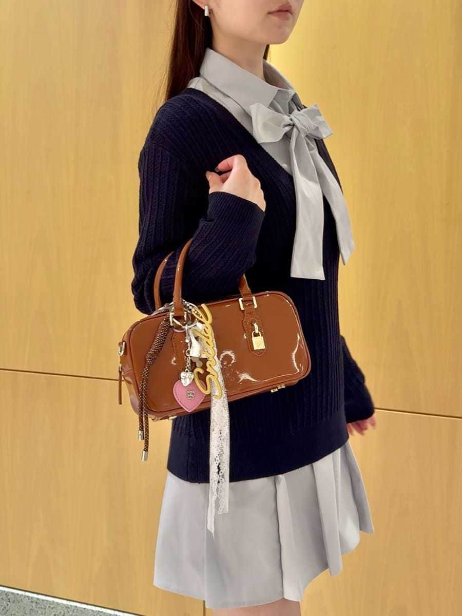 ベージュ系のステンカラーコート、ブルー系のその他トップス、ブラウン系のボストンバッグを着用したレディースの秋コーディネートの8枚目の写真