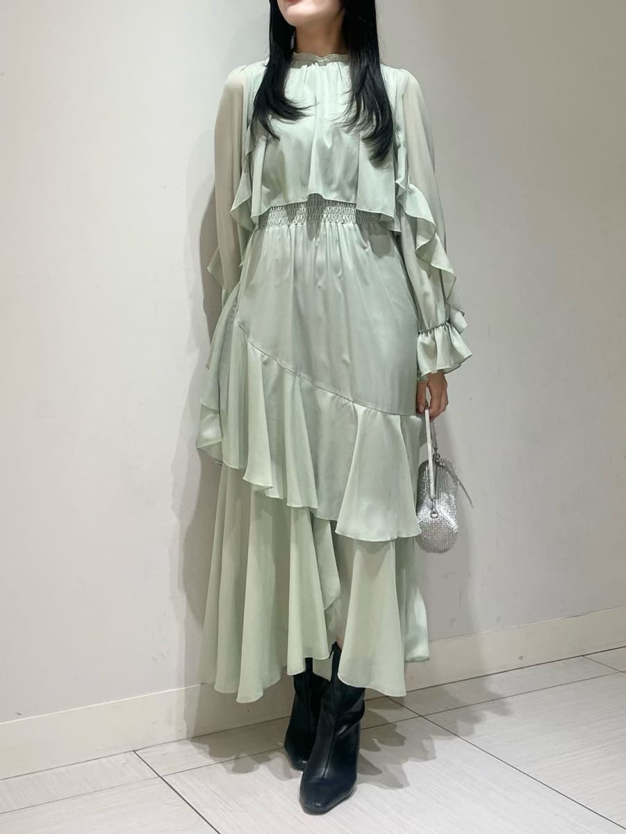 ブラック系のブーツ、ベージュ系のピーコート、グリーン系のワンピースを着用したレディースの冬コーディネートの4枚目の写真