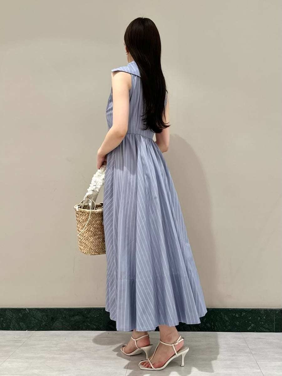 ブルー系のワンピース、ホワイト系のサンダル、ホワイト系のかごバッグを着用したレディースの夏コーディネートの2枚目の写真