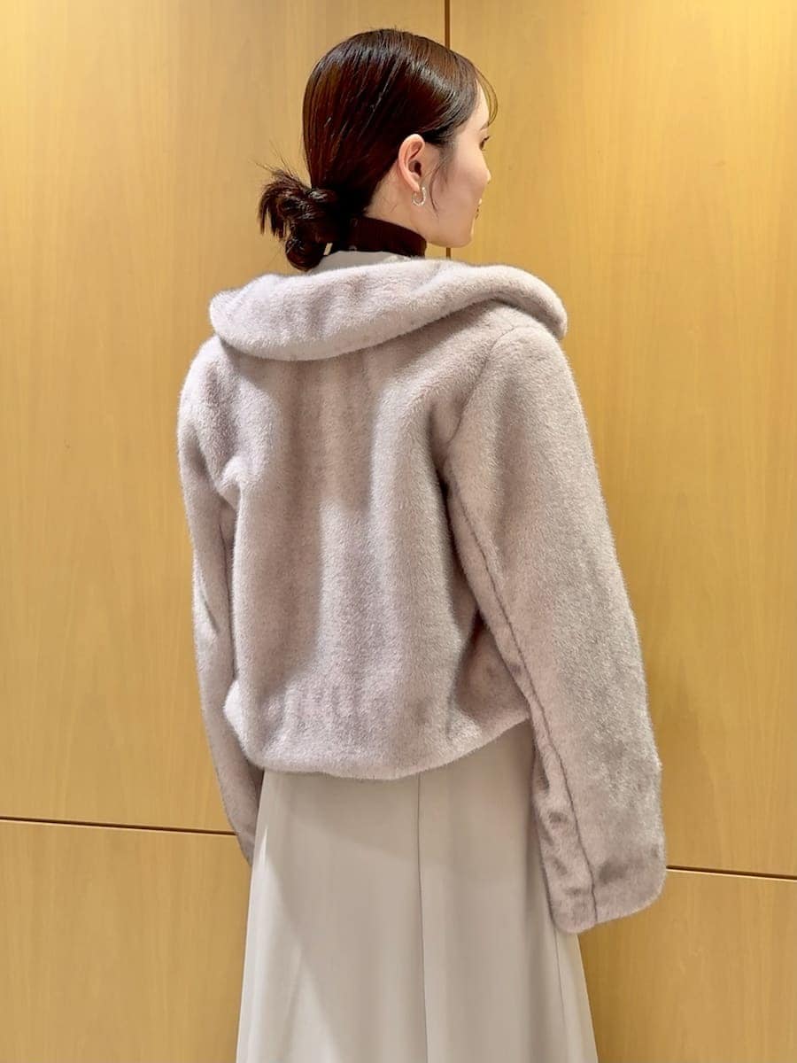 ピンク系のステンカラーコート、ベージュ系のワンピース、ブラウン系のニット/セーターを着用したレディースの秋コーディネートの6枚目の写真