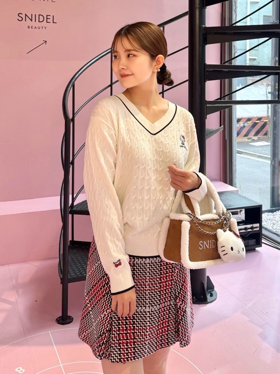 ブラック系のテーラードジャケット、ホワイト系のニット/セーター、レッド系のスカートを着用したレディースの秋コーディネートの6枚目の写真