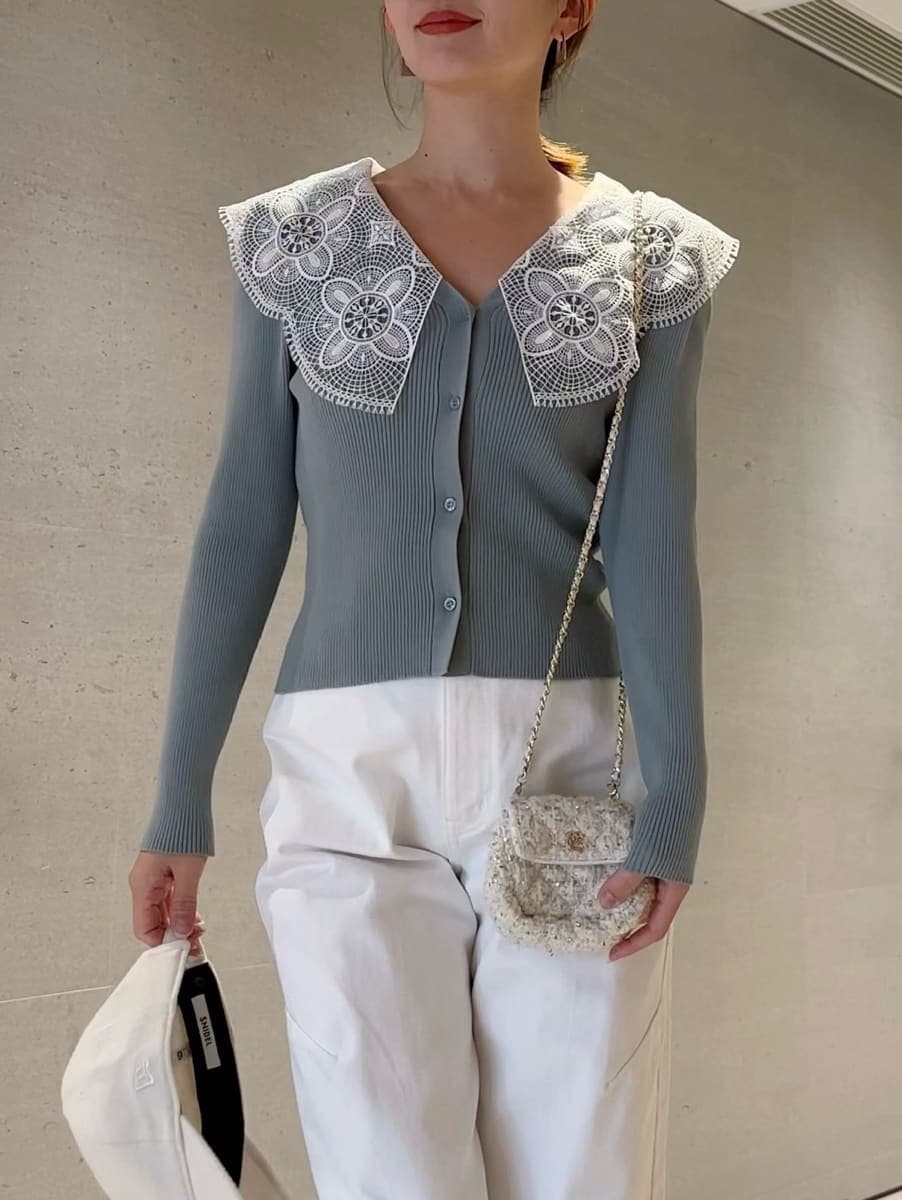 ホワイト系のショルダーバッグ、グリーン系のニット/セーター、ホワイト系のキャップを着用したレディースの冬コーディネートの4枚目の写真