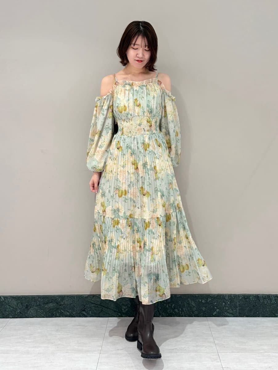 グリーン系のワンピース、ブラック系のショルダーバッグ、その他のイヤリングを着用したレディースの春コーディネートの5枚目の写真