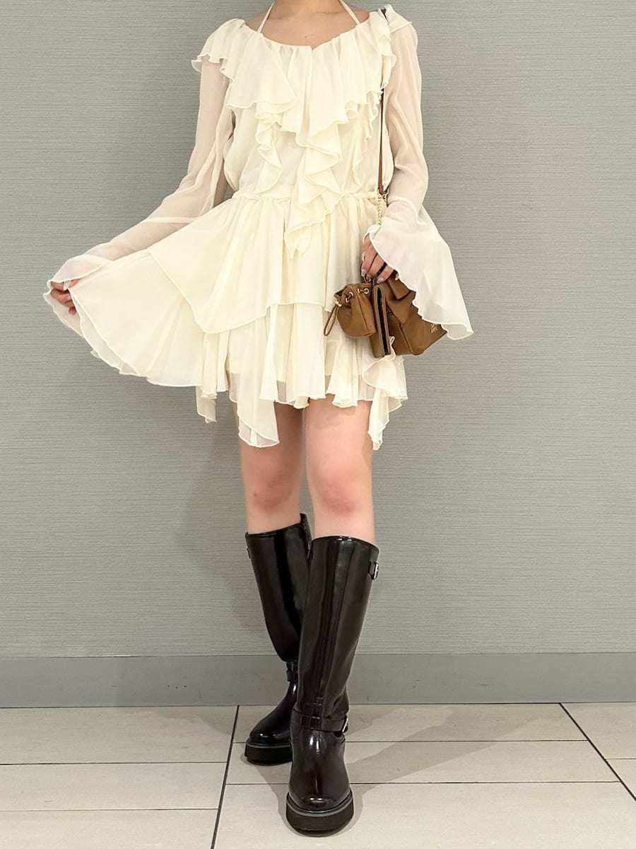 ブラウン系のブーツ、ホワイト系のワンピース、イエロー系のショルダーバッグを着用したレディースの冬コーディネートの4枚目の写真