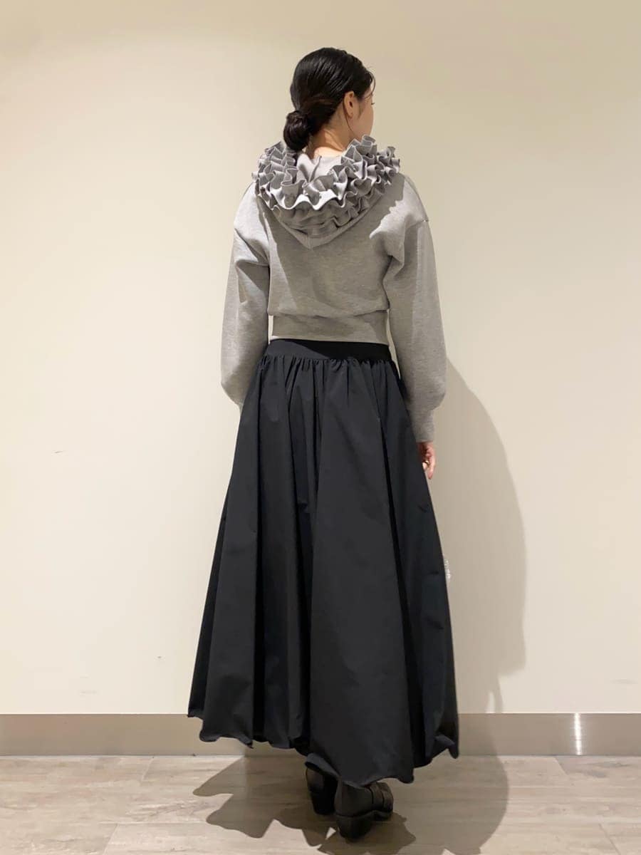 ブラック系のパンプス、グレー系のパーカー、ブラック系のスカートを着用したレディースの冬コーディネートの3枚目の写真