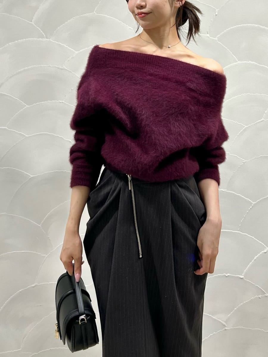 レッド系のニット/セーター、グレー系のスカート、ブラック系のハンドバッグを着用したレディースの秋コーディネートの5枚目の写真