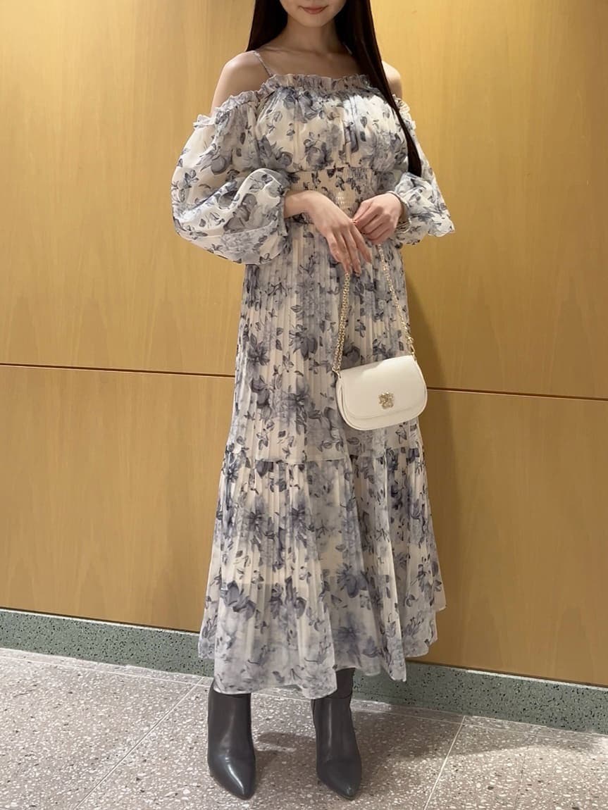 グレー系のブーツ、イエロー系のワンピース、ホワイト系のショルダーバッグを着用したレディースの冬コーディネートの2枚目の写真