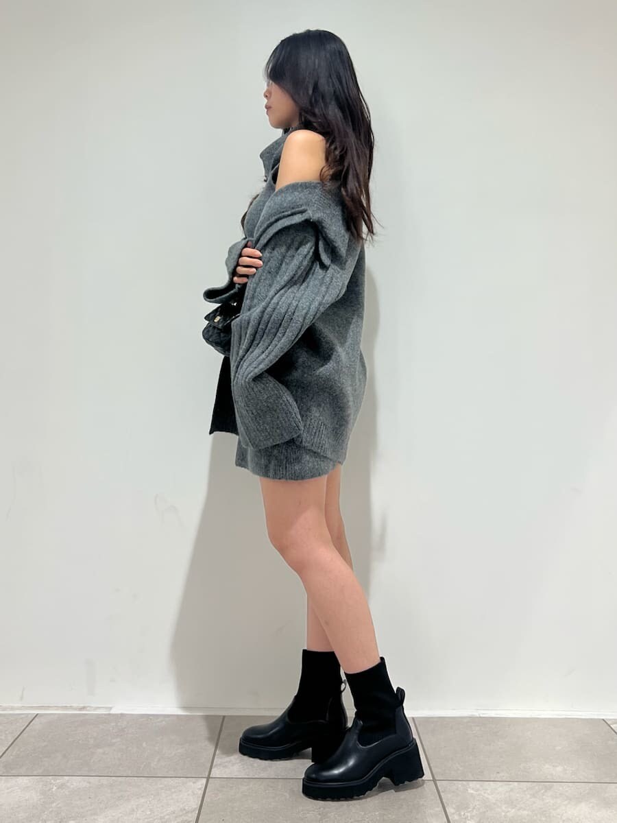 グレー系のワンピース、グレー系のカーディガン/ボレロ、ブラック系のショルダーバッグを着用したレディースの秋コーディネートの2枚目の写真