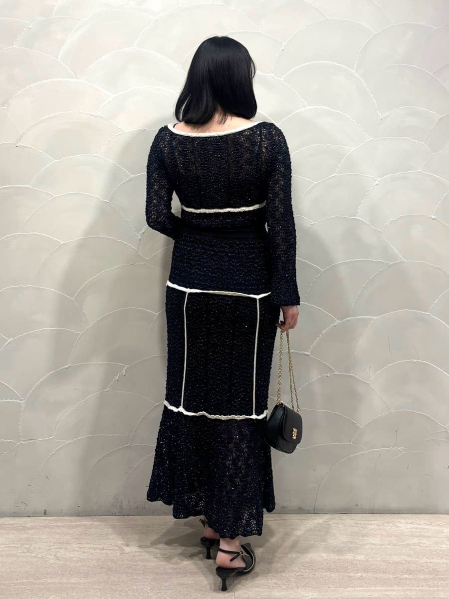 ブルー系のスカート、ブルー系のニット/セーター、ブラック系のパンプスを着用したレディースの冬コーディネートの3枚目の写真