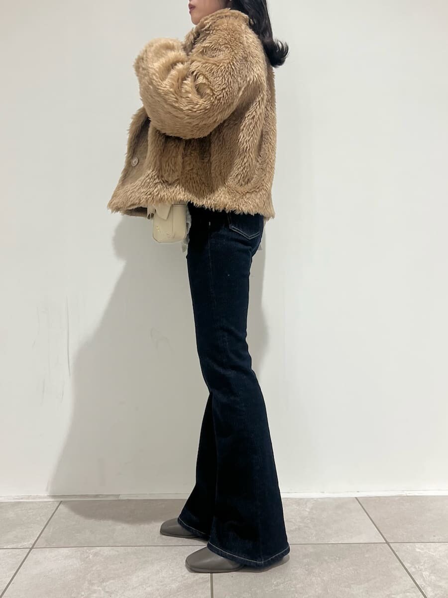 ブルー系のその他パンツ、イエロー系のムートンコート、ホワイト系のニット/セーターを着用したレディースの冬コーディネートの2枚目の写真