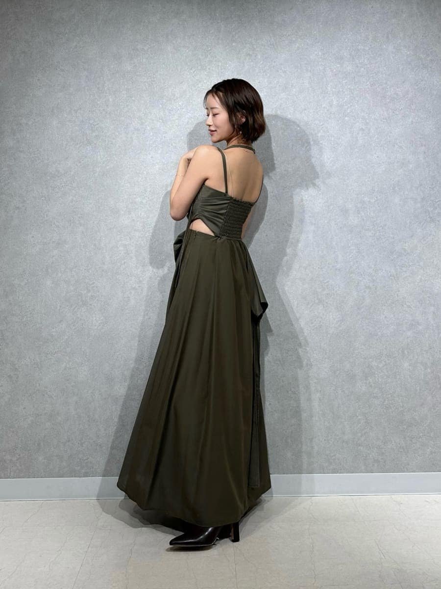 ブラウン系のブーツ、グリーン系のワンピース、ホワイト系のショルダーバッグを着用したレディースの春コーディネートの5枚目の写真