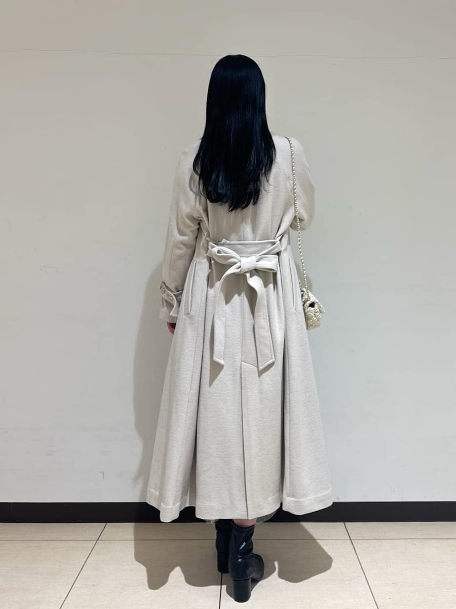 ホワイト系のショルダーバッグ、ブルー系のワンピース、ホワイト系のチェスターコートを着用したレディースの秋コーディネートの4枚目の写真