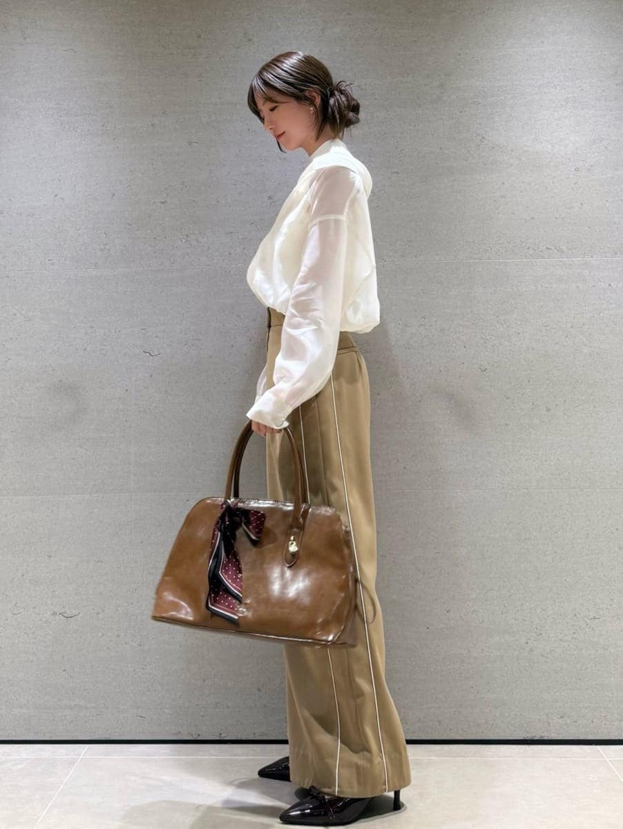 ベージュ系のその他パンツ、ホワイト系のニット/セーター、ブラウン系のハンドバッグを着用したレディースの秋コーディネートの2枚目の写真