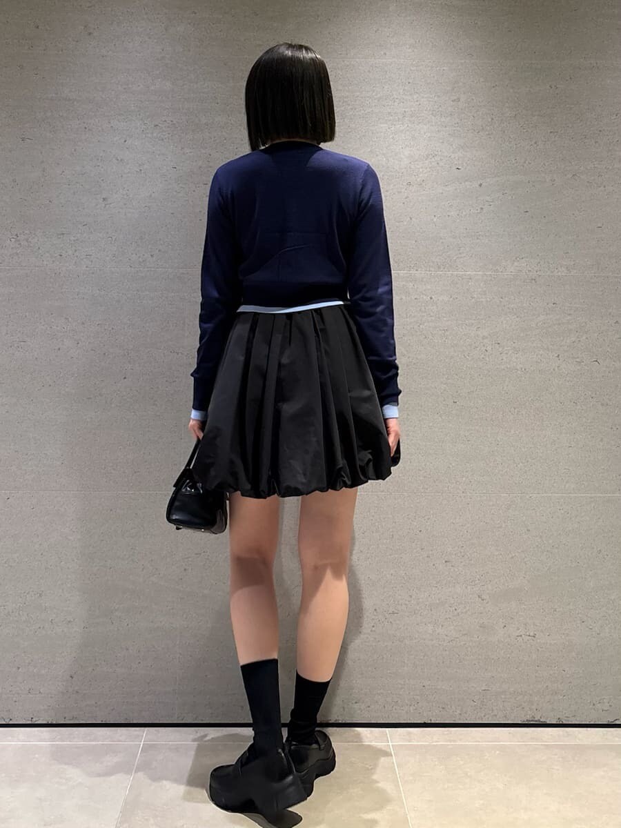 ブラック系のボストンバッグ、ブラック系のその他パンツ、ブルー系のカーディガン/ボレロを着用したレディースの冬コーディネートの4枚目の写真