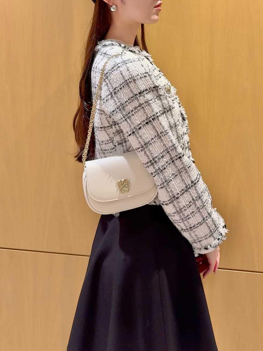 ブラック系のブーツ、ホワイト系のノーカラージャケット、ブラック系のその他パンツを着用したレディースの冬コーディネートの8枚目の写真