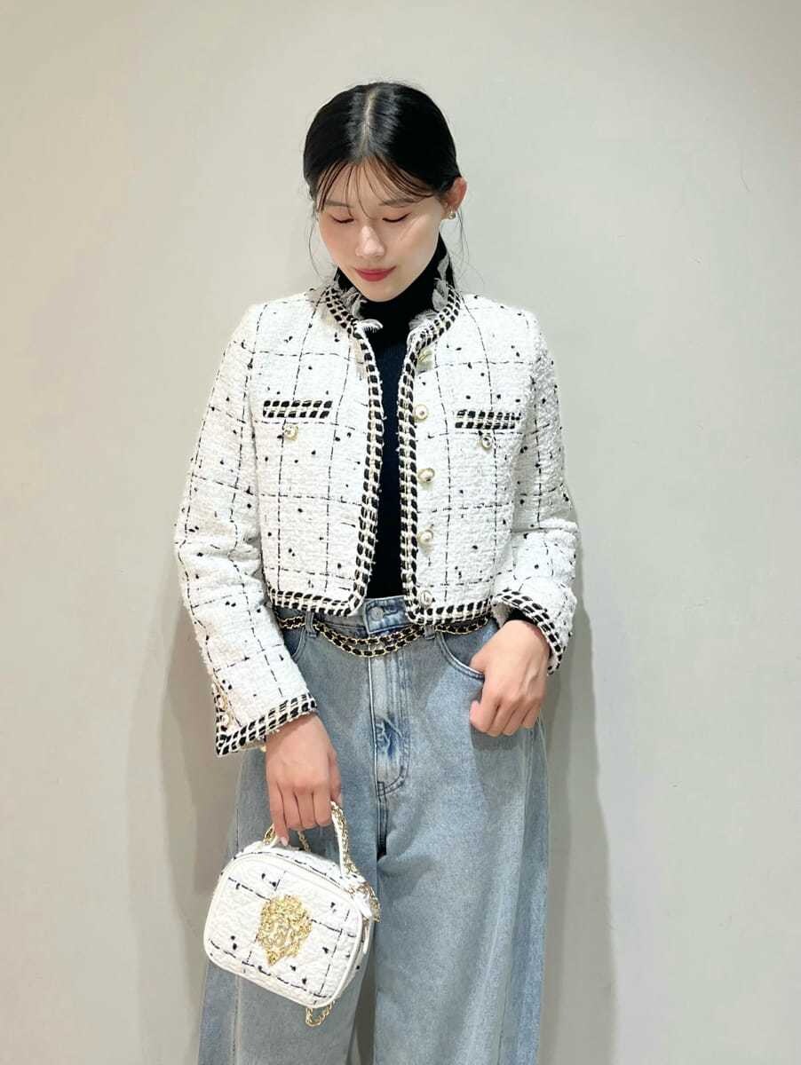 ホワイト系のノーカラージャケット、ブルー系のデニムパンツ、ブラック系のニット/セーターを着用したレディースの秋コーディネートの4枚目の写真