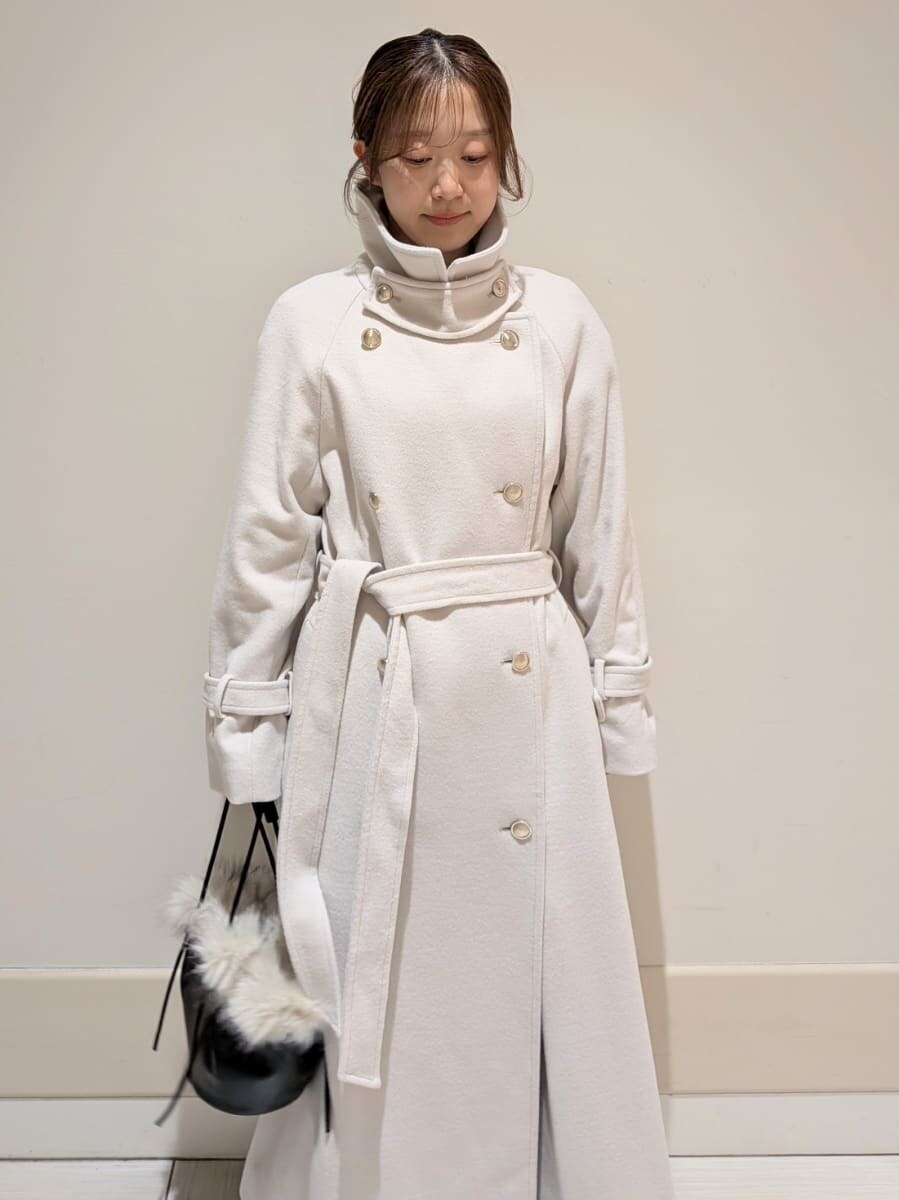 ブラック系のブーツ、ホワイト系のチェスターコート、グレー系のワンピースを着用したレディースの秋コーディネートの4枚目の写真