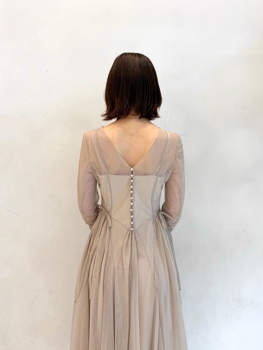 グレー系のドレス、ブラック系のパンプス、ホワイト系のハンドバッグを着用したレディースの冬コーディネートの6枚目の写真