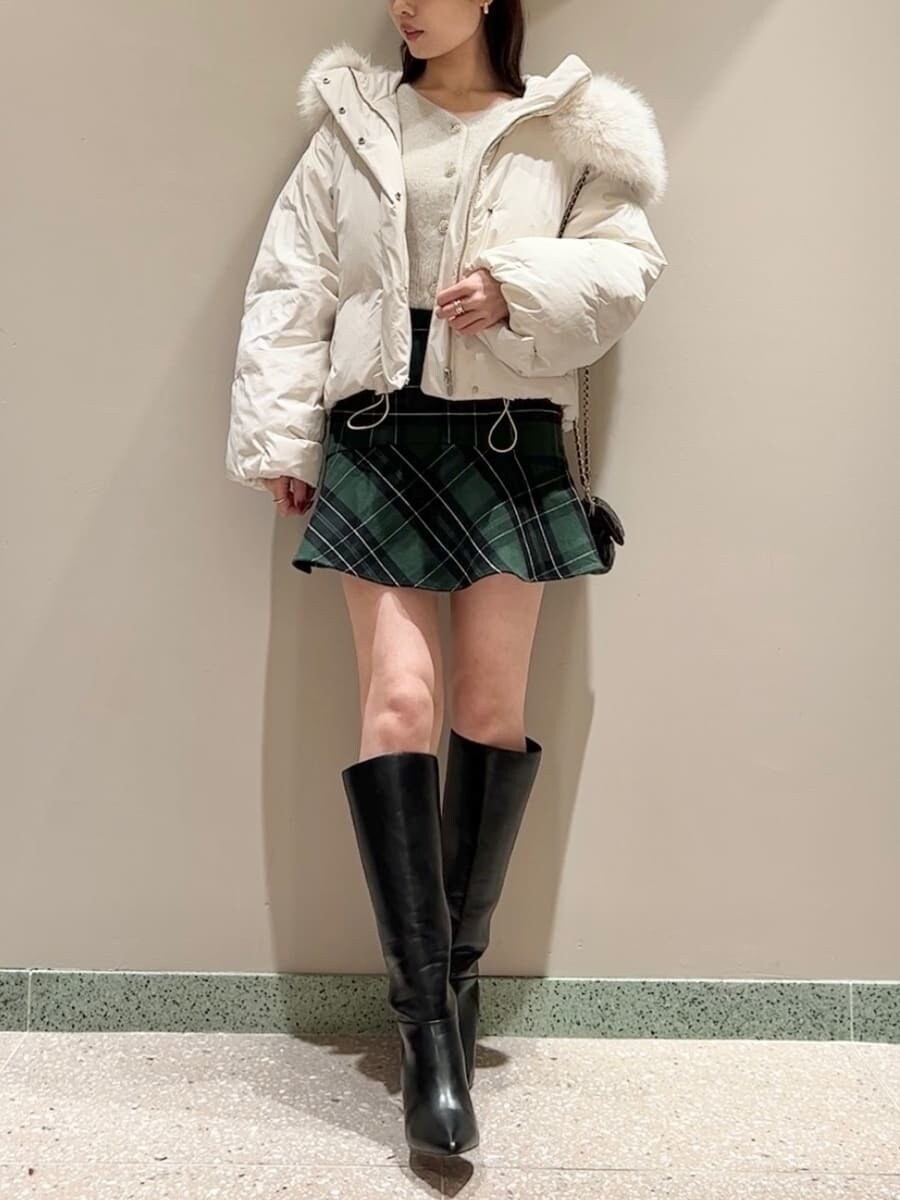 ブラック系のブーツ、ブラック系のショルダーバッグ、ホワイト系のダウンジャケット/コートを着用したレディースの冬コーディネートの4枚目の写真