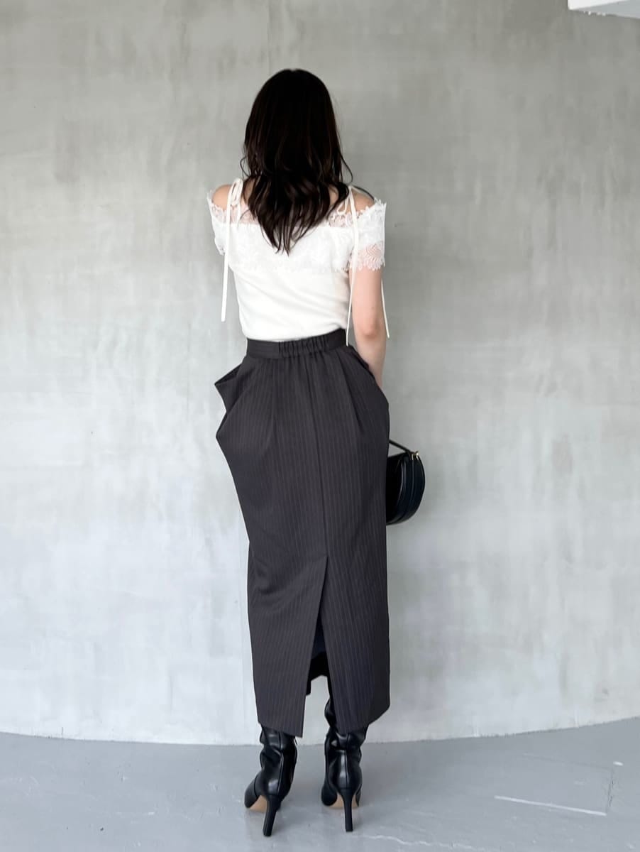 ホワイト系のニット/セーター、グレー系のスカート、ブラック系のブーツを着用したレディースの秋コーディネートの4枚目の写真