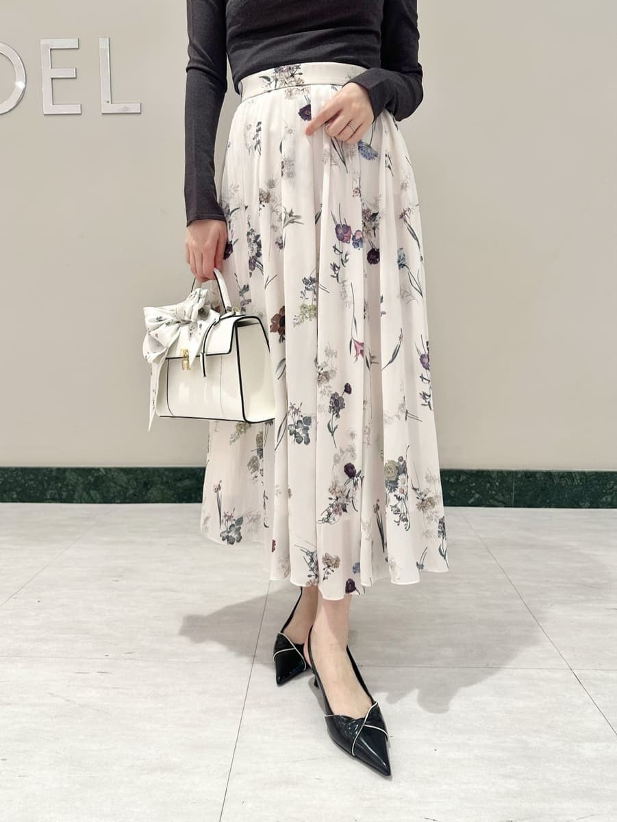 ホワイト系のスカート、グレー系のニット/セーター、ブラック系のパンプスを着用したレディースの冬コーディネートの3枚目の写真