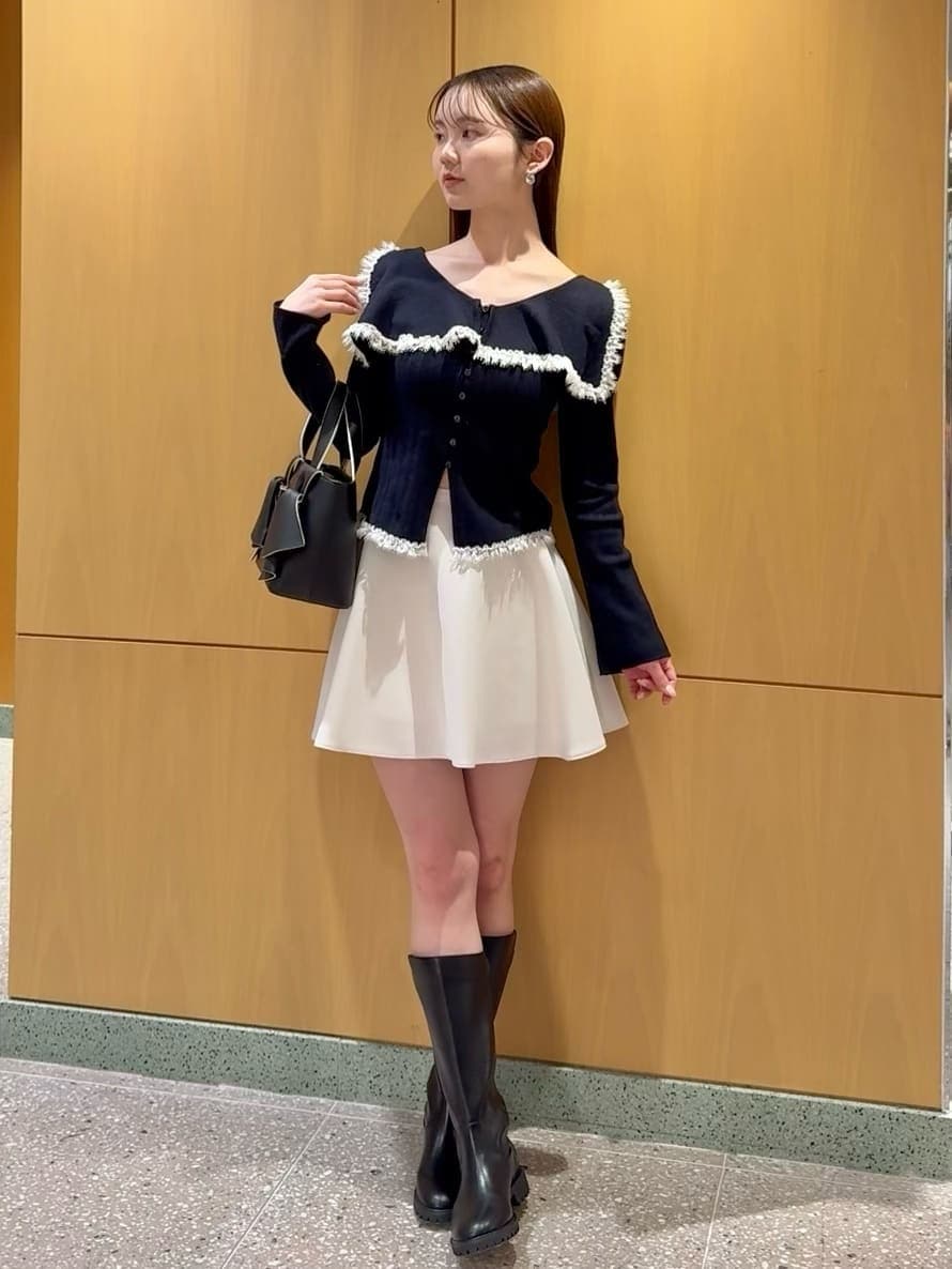 ブルー系のニット/セーター、ホワイト系のその他パンツ、ブラック系のハンドバッグを着用したレディースの冬コーディネートの2枚目の写真