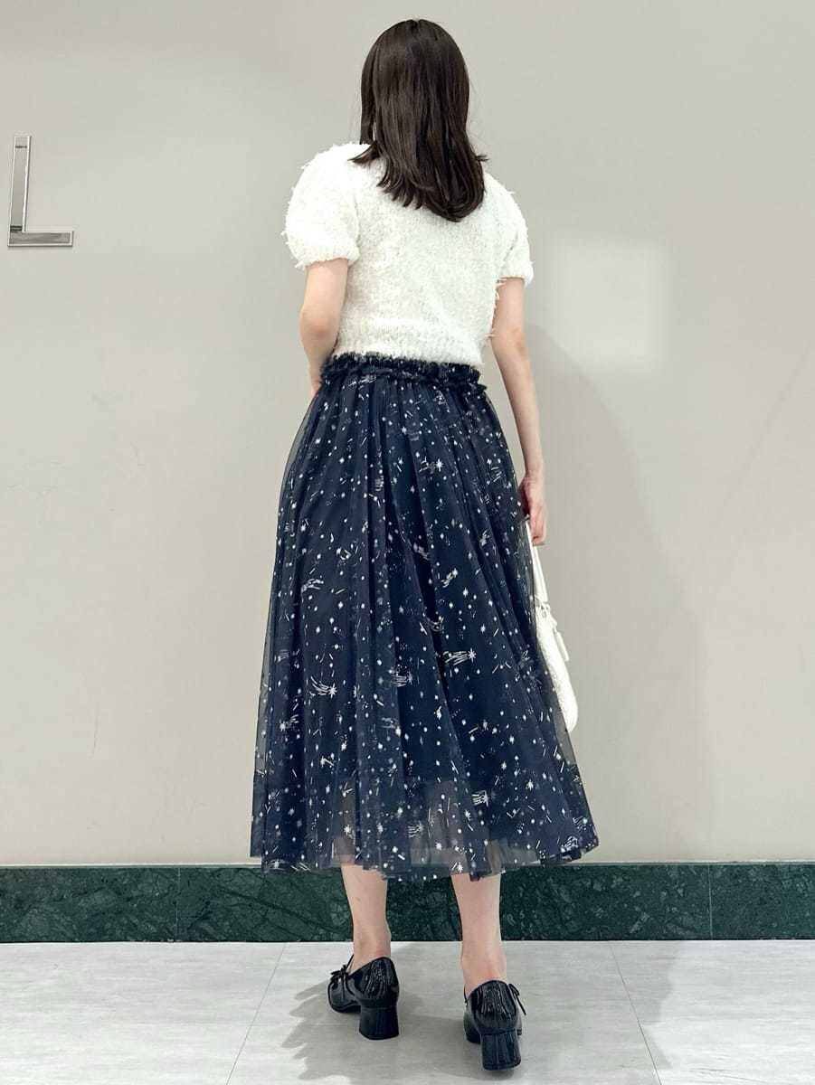 ホワイト系のニット/セーター、ブルー系のスカート、ブラック系のパンプスを着用したレディースの夏コーディネートの5枚目の写真