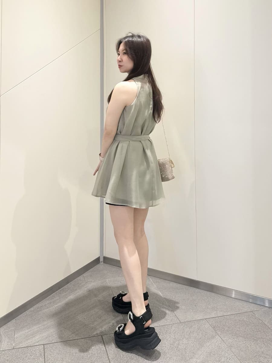 ブラック系のその他パンツ、グリーン系のシャツ/ブラウス、ブラック系のサンダルを着用したレディースの春コーディネートの3枚目の写真