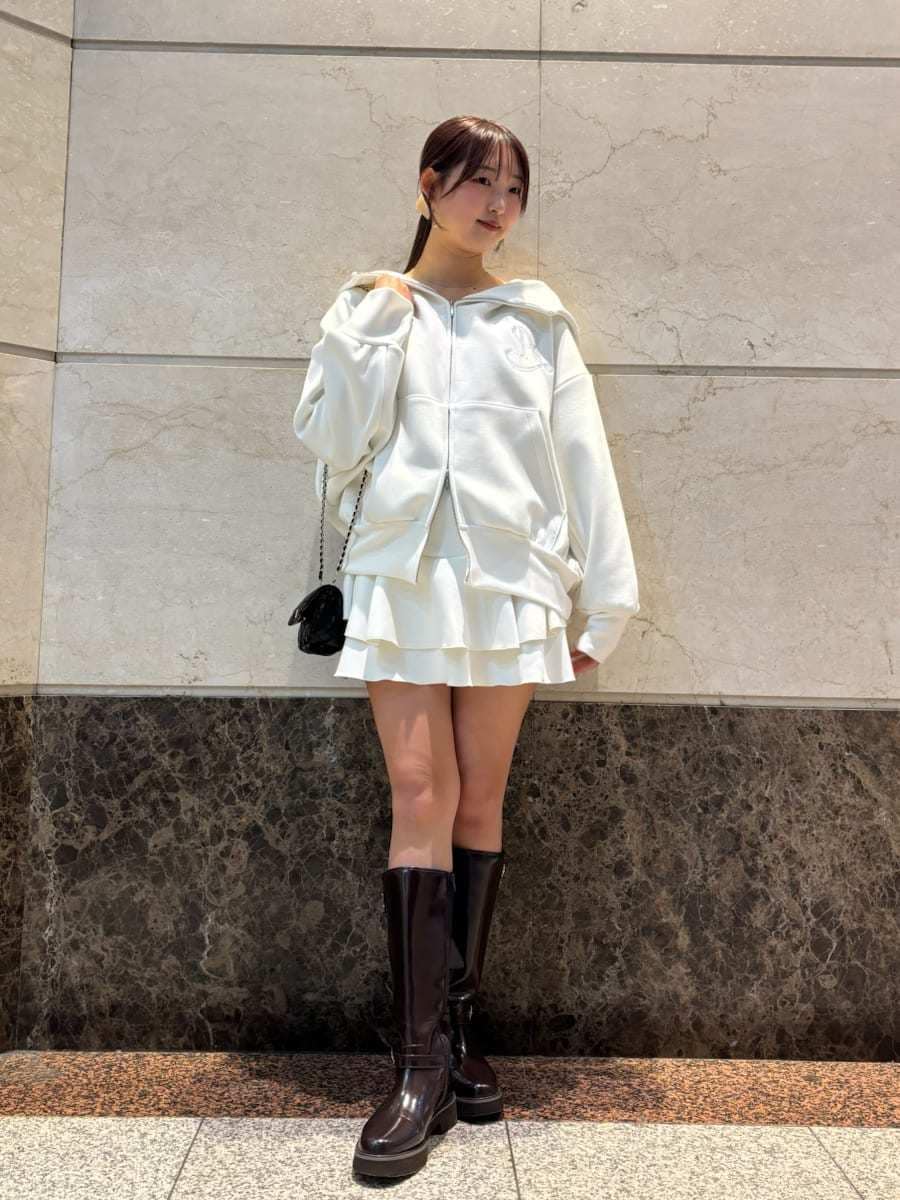 ブラウン系のブーツ、ブラック系のショルダーバッグ、ホワイト系のパーカーを着用したレディースの冬コーディネートの2枚目の写真