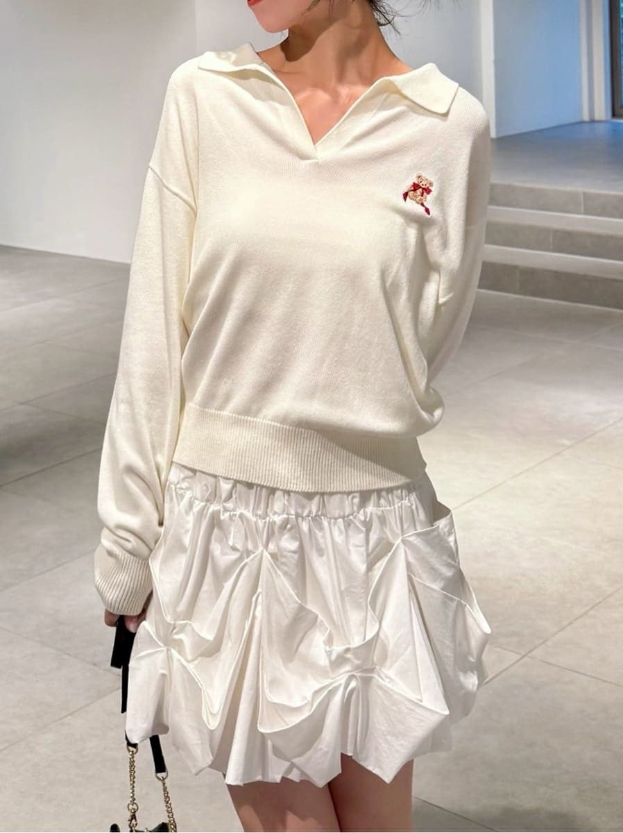 ホワイト系のキャミソール、ブラック系のブーツ、ブラウン系のステンカラーコートを着用したレディースの秋コーディネートの3枚目の写真