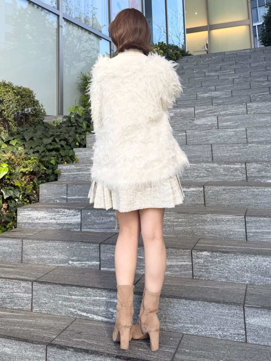 ホワイト系のスカート、ホワイト系のカーディガン/ボレロ、ホワイト系のハンドバッグを着用したレディースの冬コーディネートの9枚目の写真