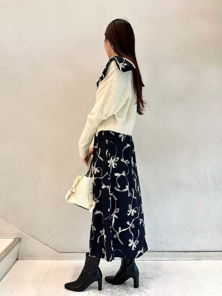 ブルー系のワンピース、ベージュ系のカーディガン/ボレロ、ブラック系のブーツを着用したレディースの秋コーディネートの2枚目の写真