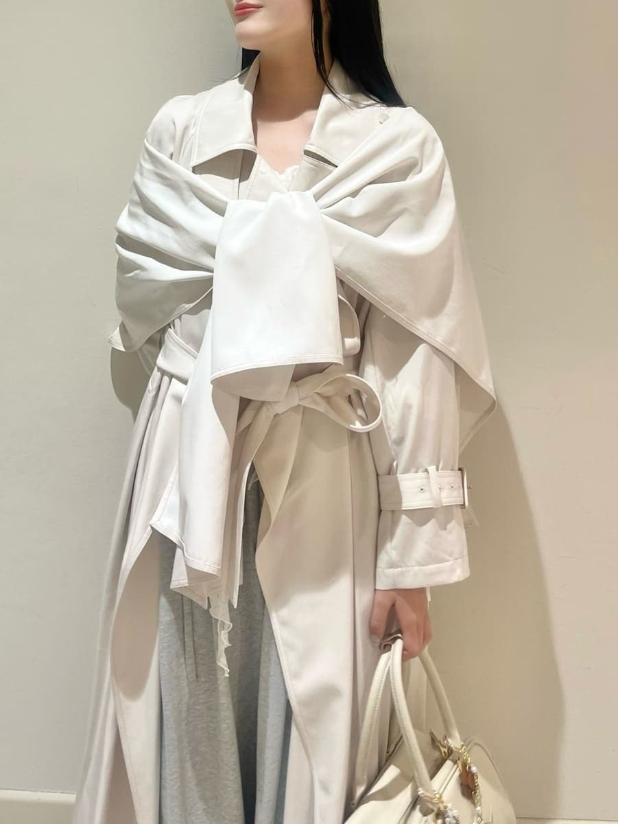 ブラック系のブーツ、ホワイト系のトレンチコート、グレー系のその他パンツを着用したレディースの冬コーディネートの5枚目の写真