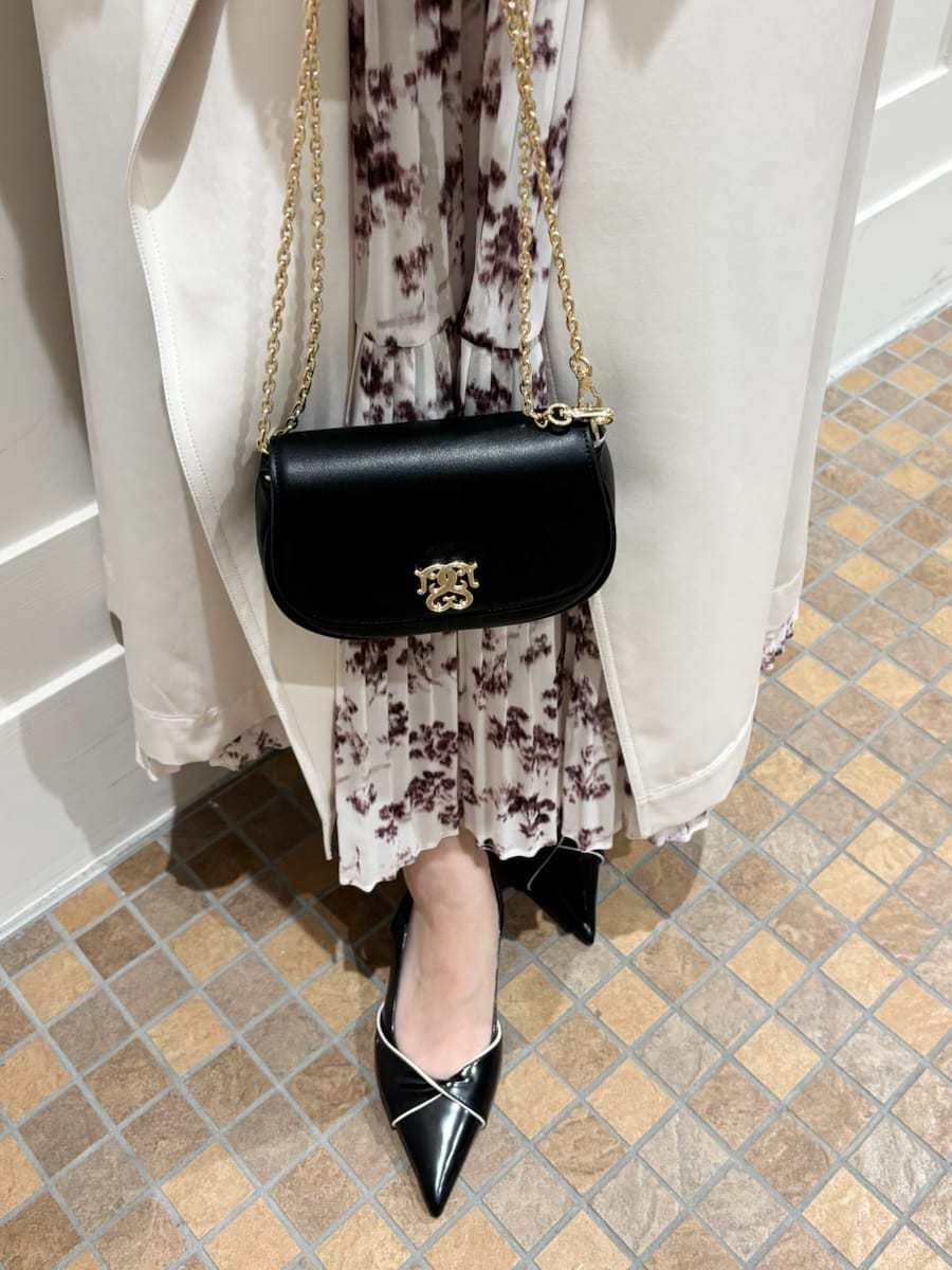 ホワイト系のトレンチコート、ピンク系のワンピース、ブラック系のパンプスを着用したレディースの冬コーディネートの6枚目の写真