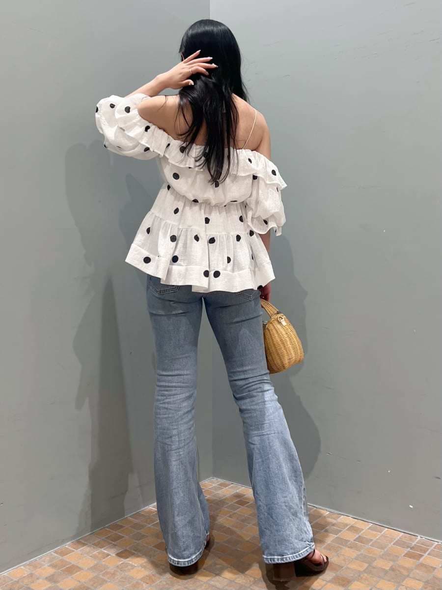ブルー系のデニムパンツ、ホワイト系のかごバッグ、ホワイト系のシャツ/ブラウスを着用したレディースの春コーディネートの2枚目の写真