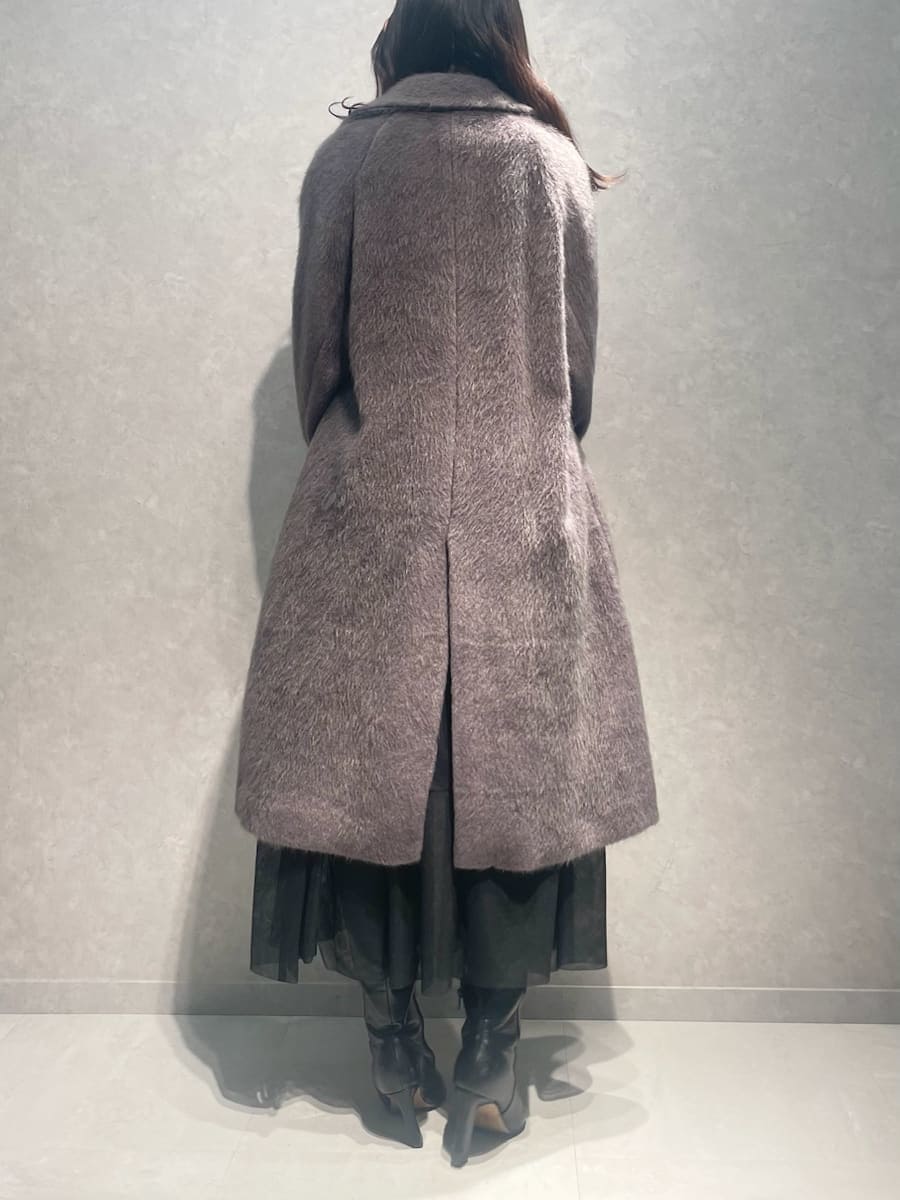 ブラック系のブーツ、グレー系のチェスターコート、ブラック系のスカートを着用したレディースの冬コーディネートの3枚目の写真