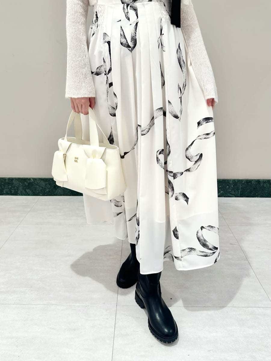 ホワイト系のワンピース、ホワイト系のハンドバッグを着用したレディースの冬コーディネートの3枚目の写真